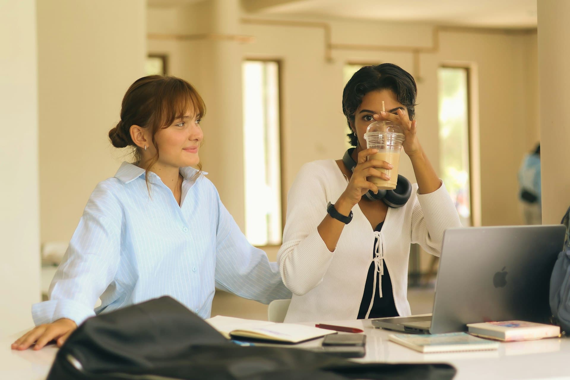 Two women studying together with coffee and laptop